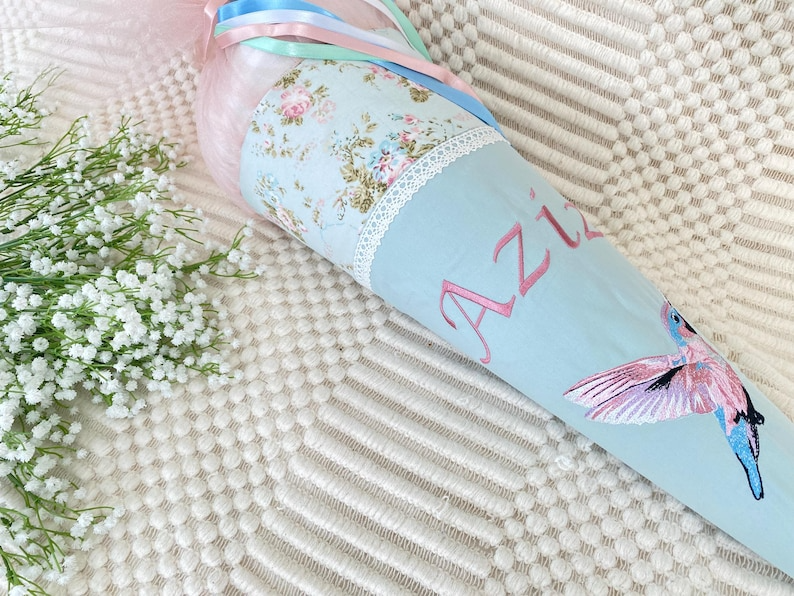 Schultüte mit buntem Kolibri und personalisierter Stickerei schräg ausgerichtet