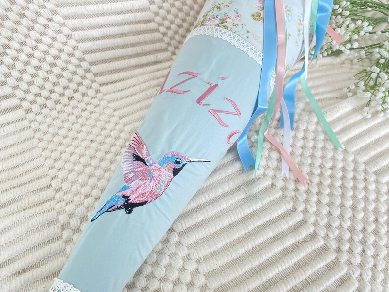 Schultüte mit buntem Kolibri und personalisierter Stickerei gerade Kolibri vollständig zu sehen auf Teppich