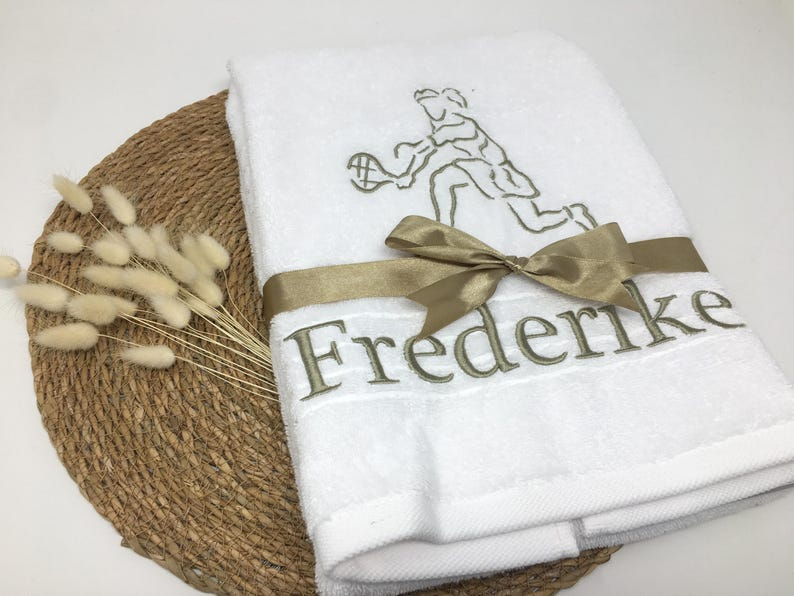 Tennis Frau Stickmotiv auf weißem Handtuch mit grüngrauer Schleife